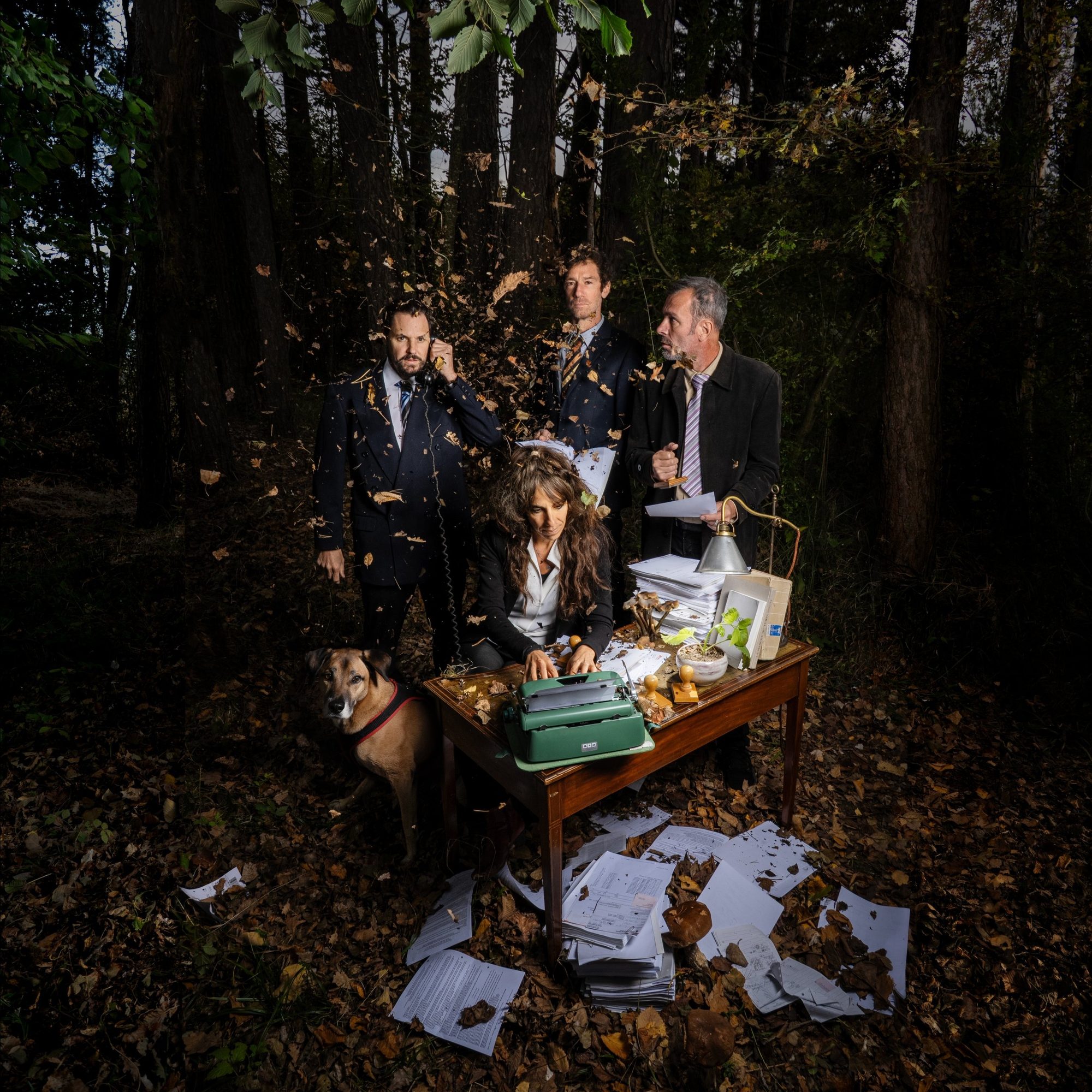 Inszeniertes Gruppenbild im Wald: Büro mit Schreibmaschine, Akten und Laub, SPAM’Z